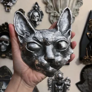 Máscara de gato hecha a mano en un acabado metálico brillante, perfecta para decoración sofisticada y oscura.