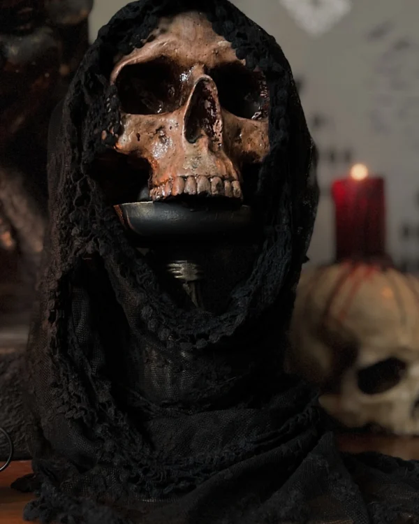 Escultura de calavera cubierta con un velo negro, ideal para decoración oscura y sofisticada.