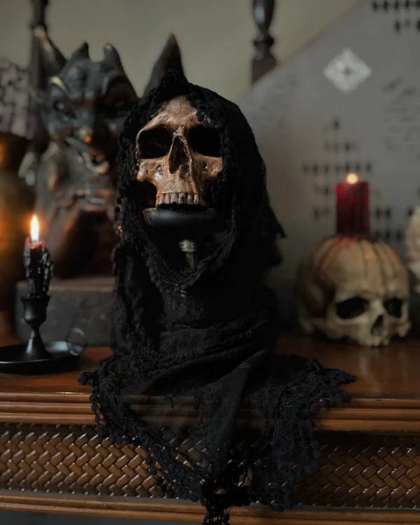 Escultura de calavera cubierta con un velo negro, ideal para decoración oscura y sofisticada.