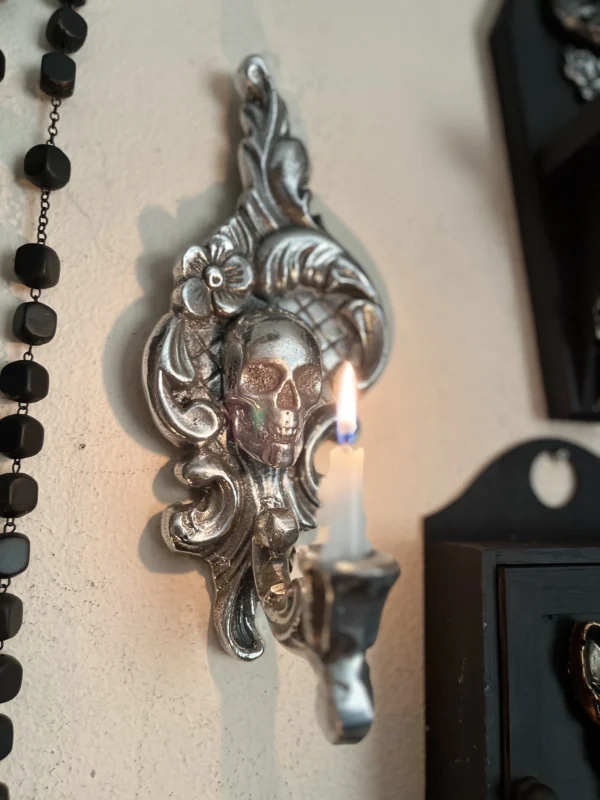 Candelabro artesanal con diseño de calavera y detalles ornamentales en plata, ideal para una decoración oscura y sofisticada.