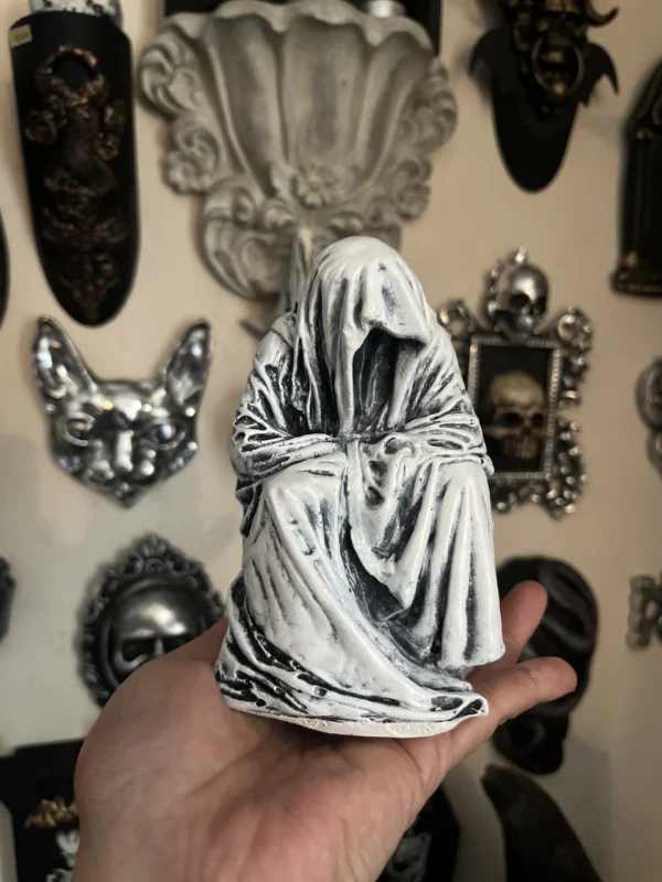 Escultura de figura fantasmal en blanco y negro, realizada a mano, perfecta para ambientes oscuros y sofisticados.